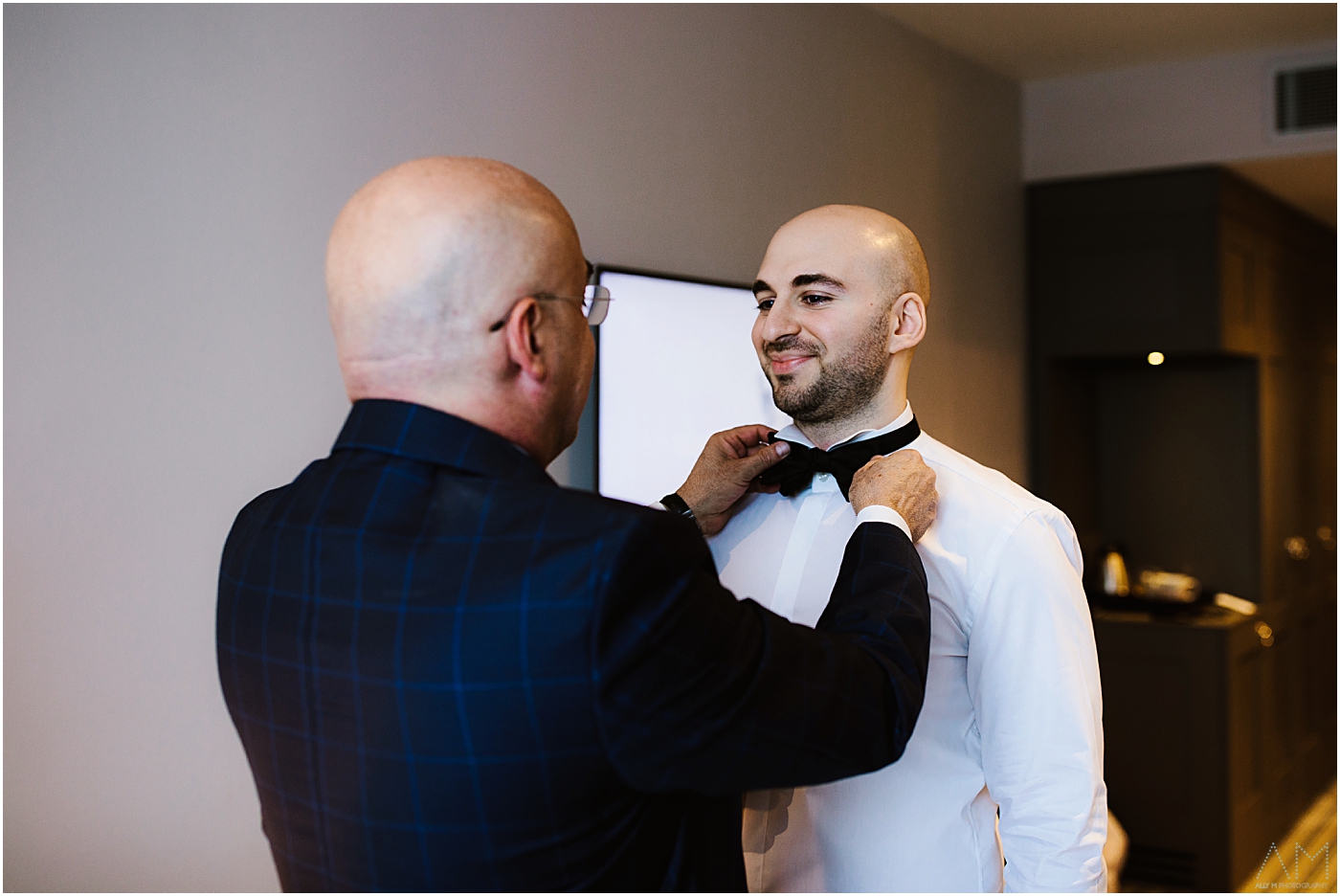 groom having bow tie fastened