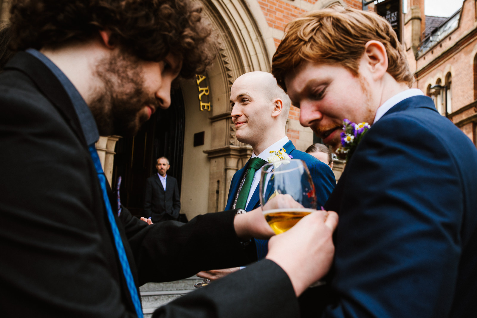 Groomsman helping friend with buttonhole