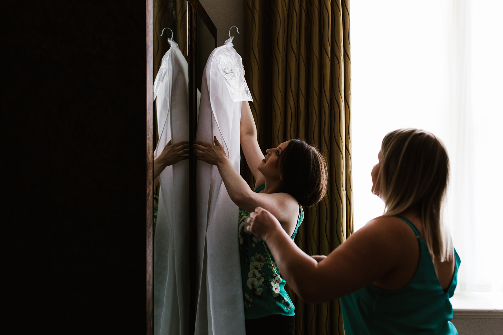 Bride getting down her wedding dress.