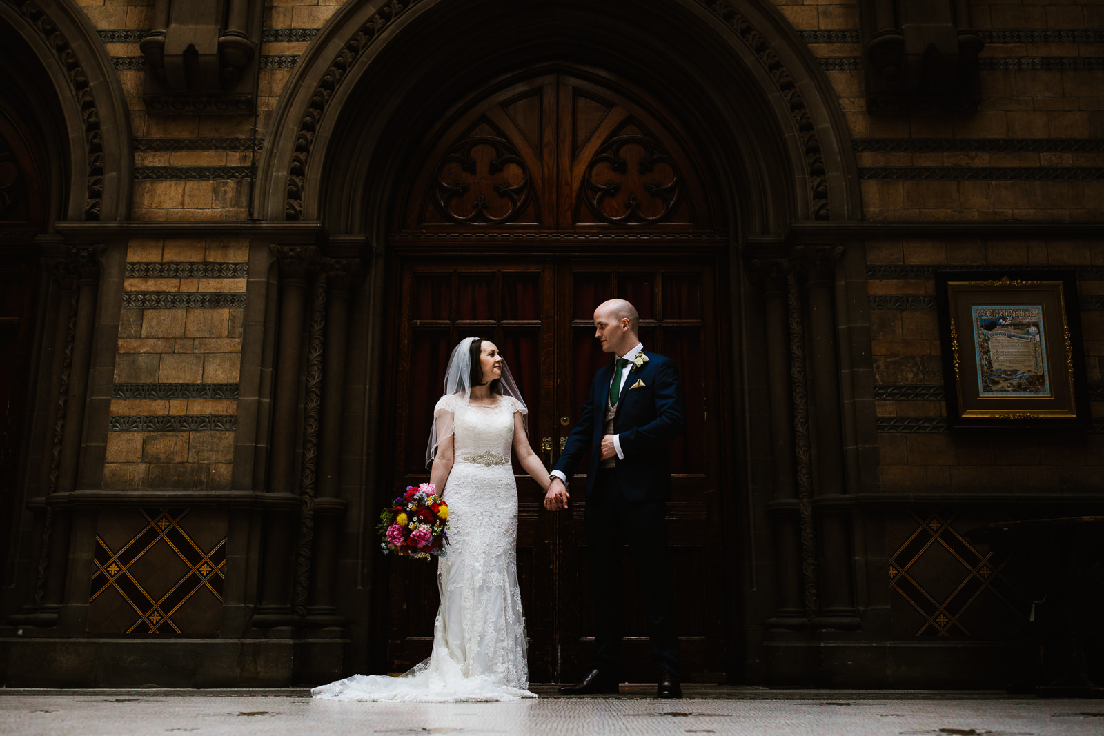 Bride and groom stood in front of grand doors