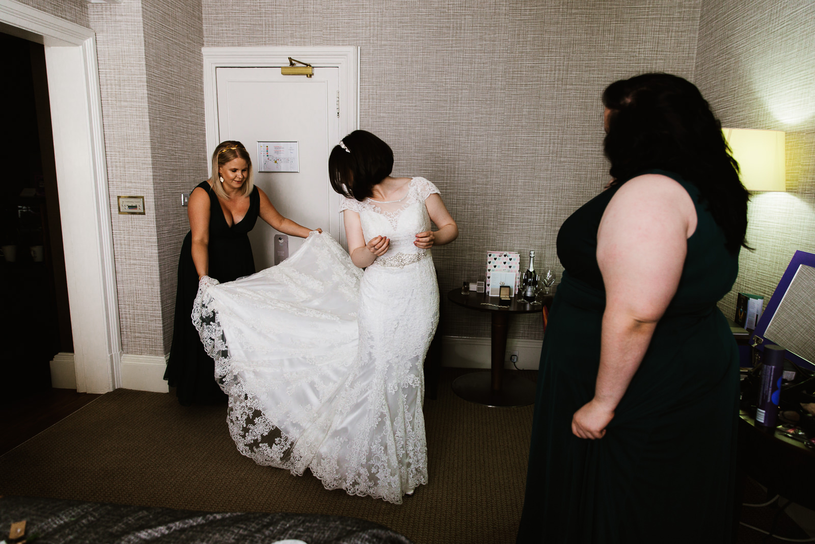 Bridesmaid holding wedding dress.