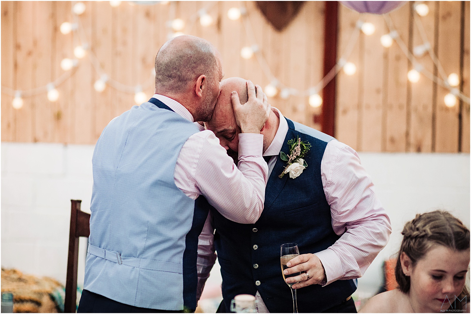 Groom kissing best man on the head