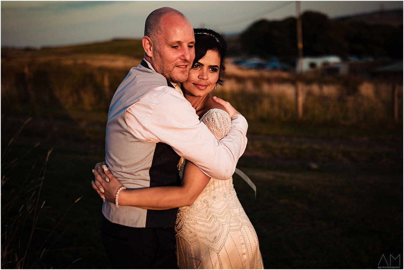 Bride and groom holding each other during sunset