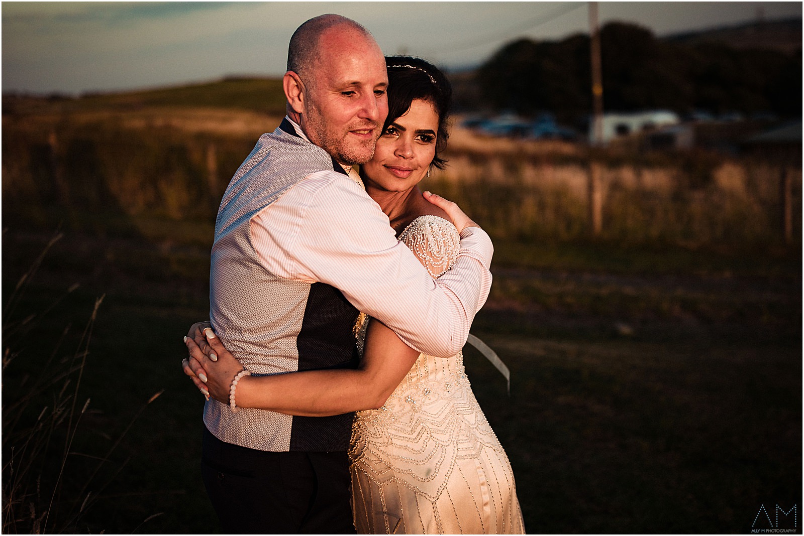 Bride and groom holding each other during sunset