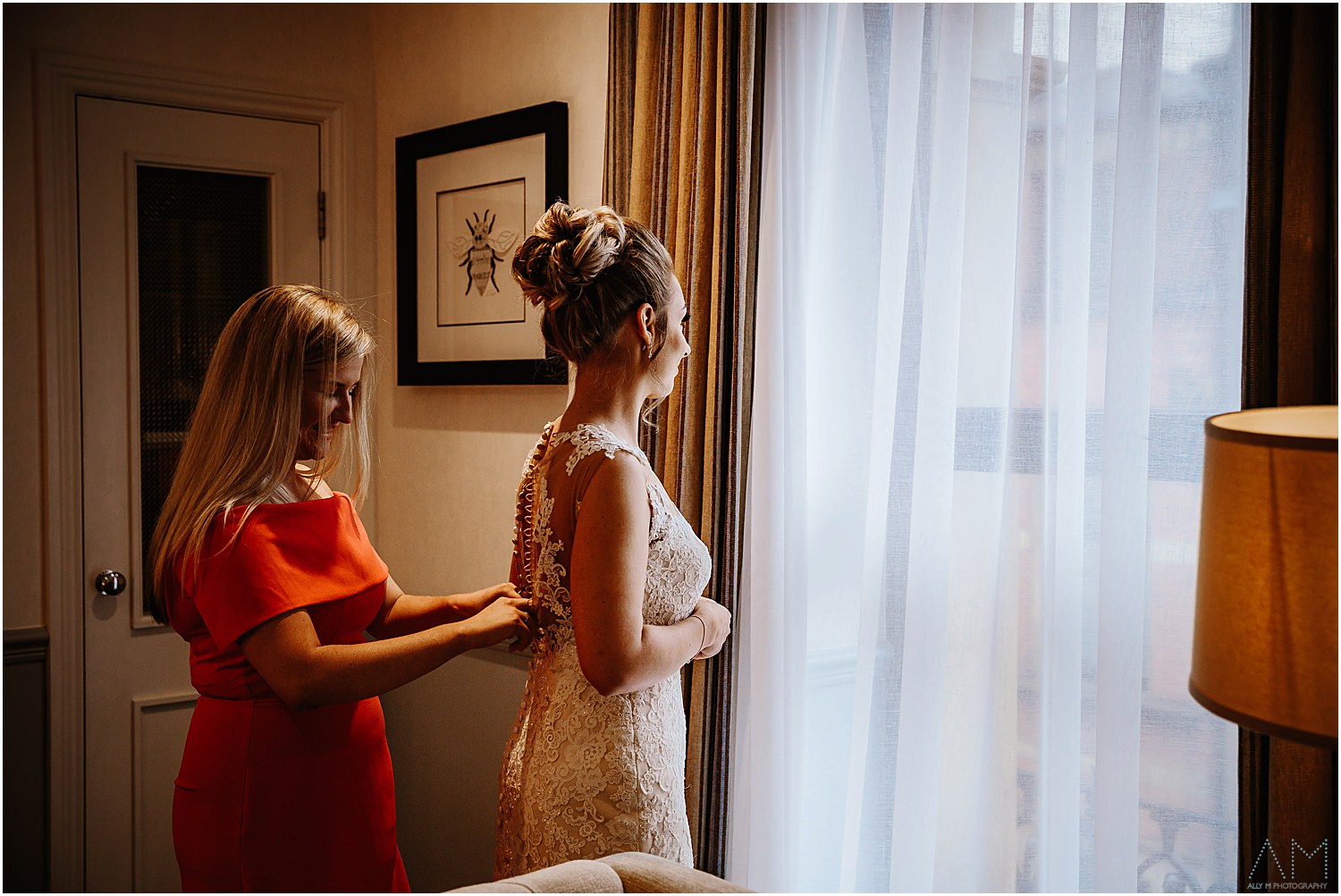 Bride getting helped into her wedding dress
