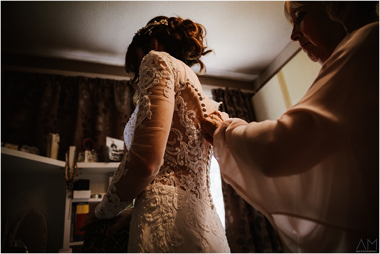 Mum helping her daughter into her dress