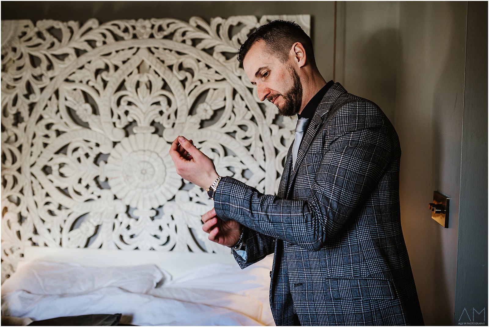 Groom doing up his jacket