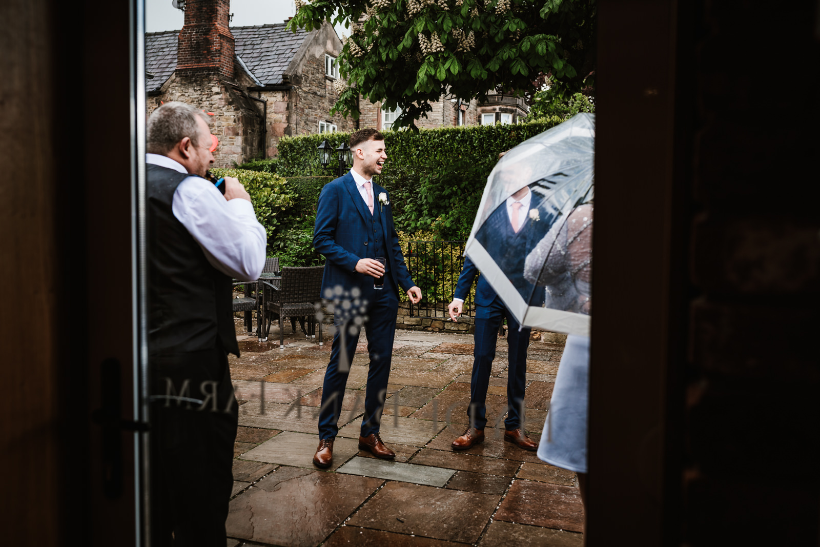 Groom with his guests in the rain
