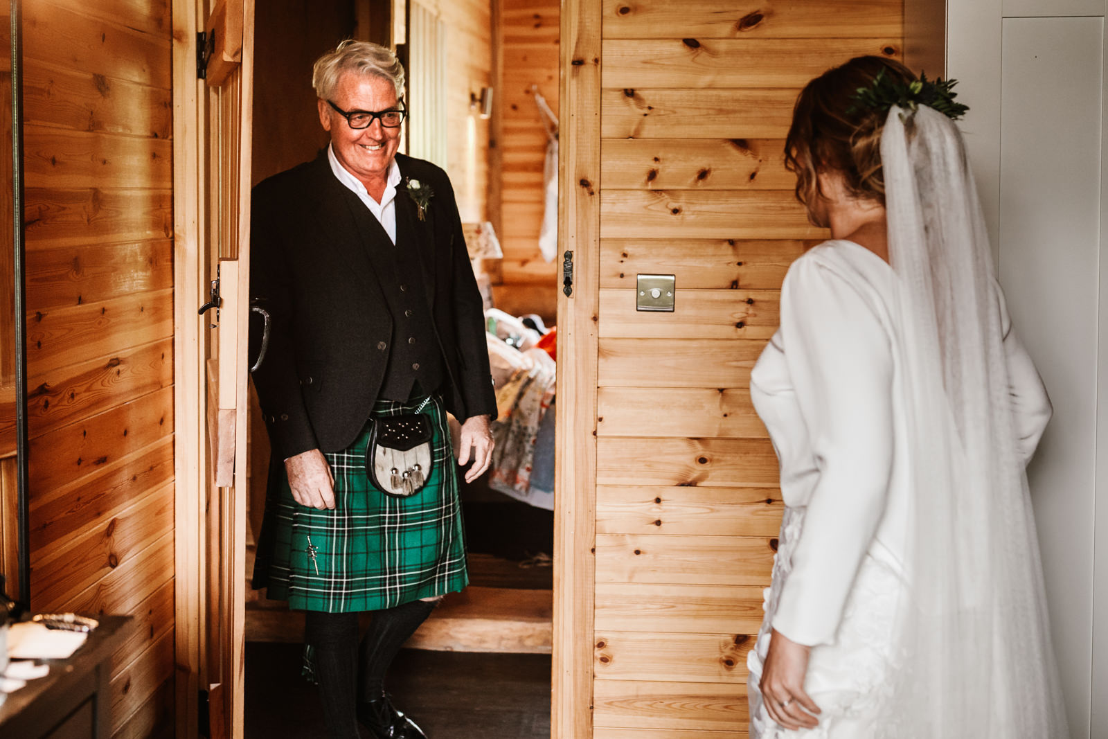 Father of the bride looks at his daughter for the first time in her wedding dress