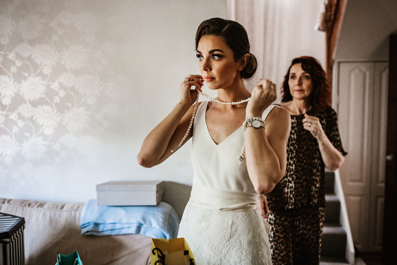 Lester Meadows Tipi Wedding Cheshire 6 Bride putting on a pearl necklace