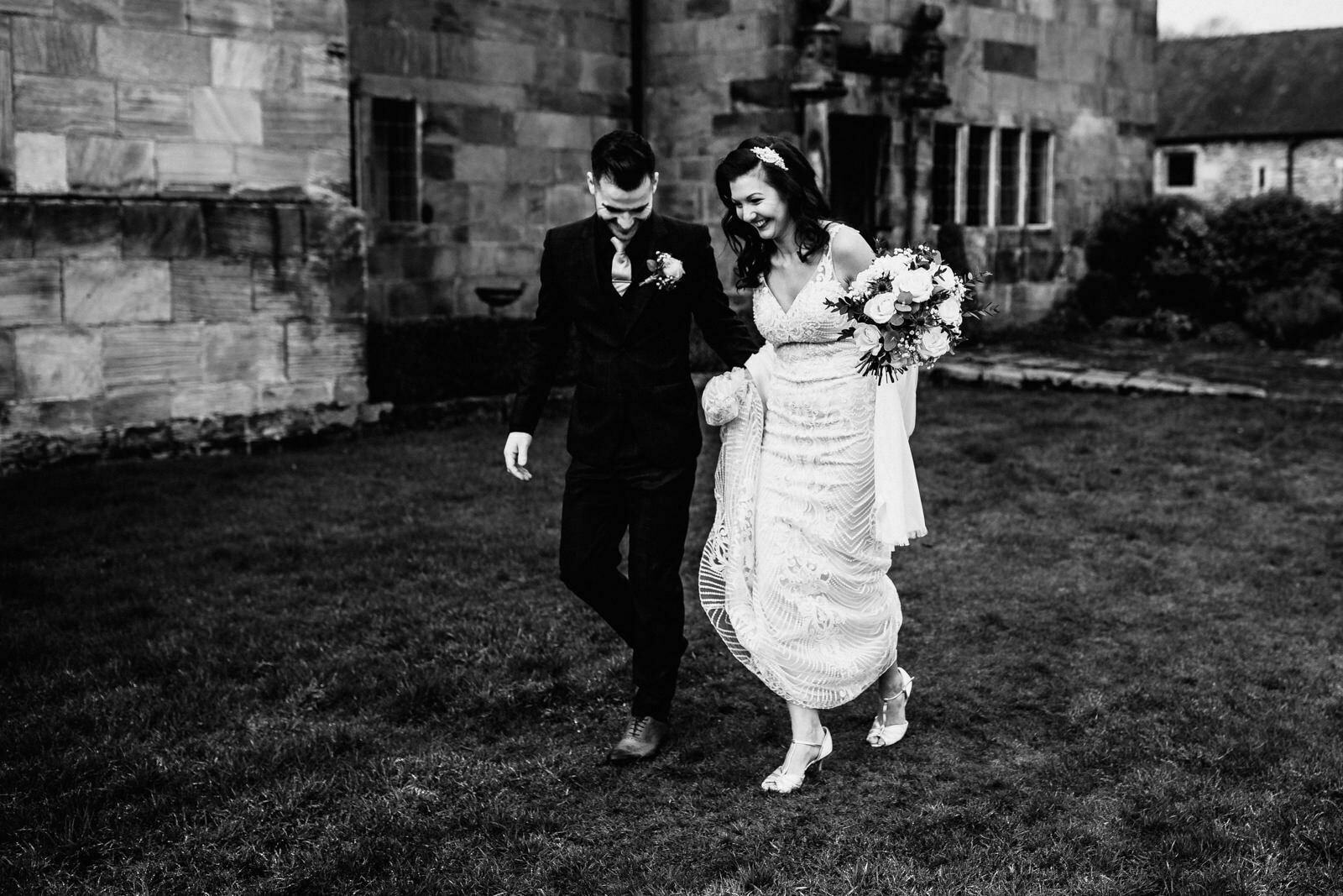bride and groom walking through the gardens at The Ashes Barns