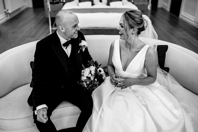 Bride and groom smiling together in the bridal suite