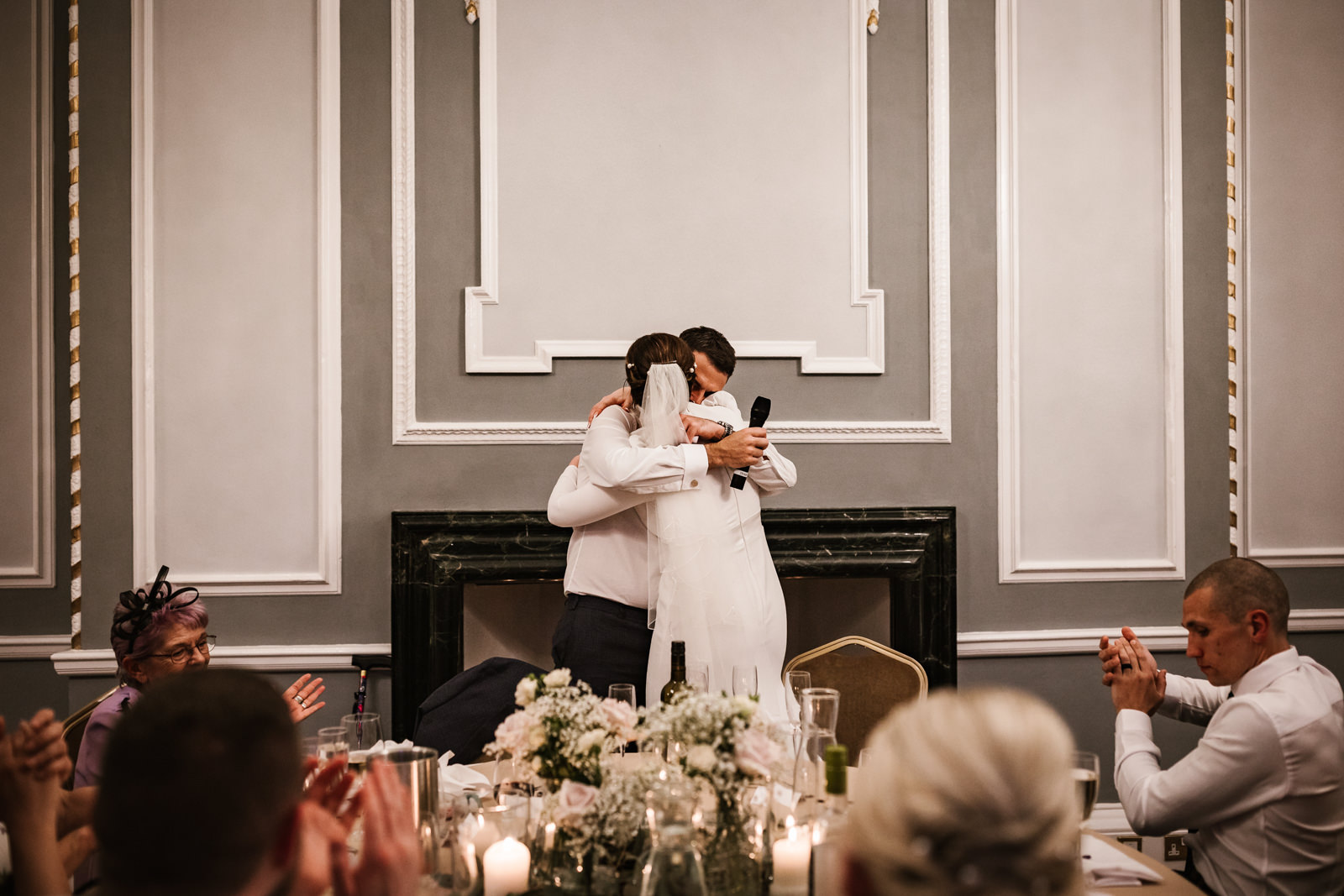 Bride and groom hugging during speeches