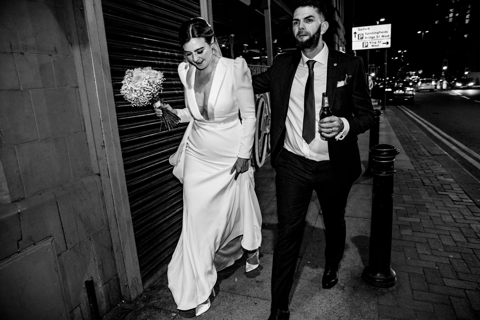 Bride and groom walking through manchester