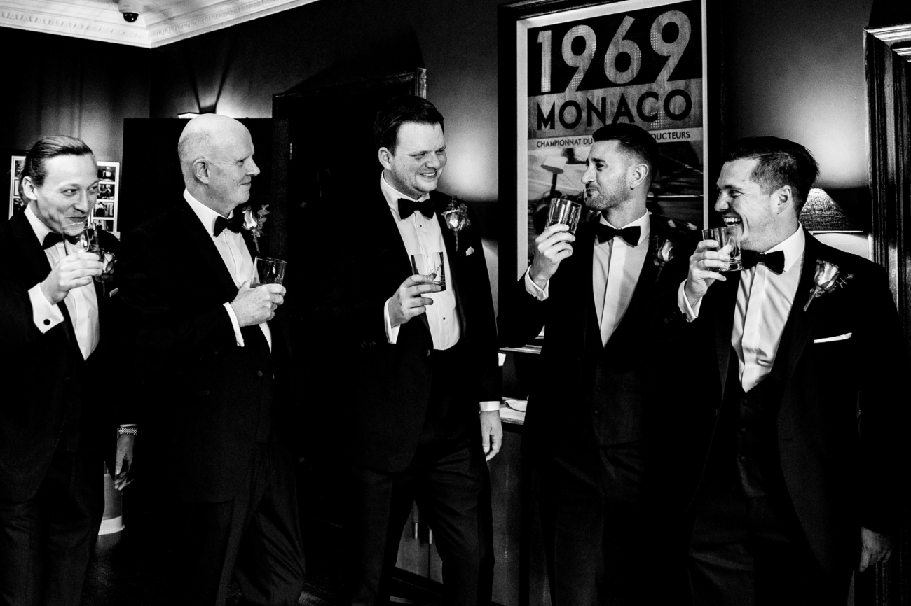 Groom and his groomsmen toasting with a drink