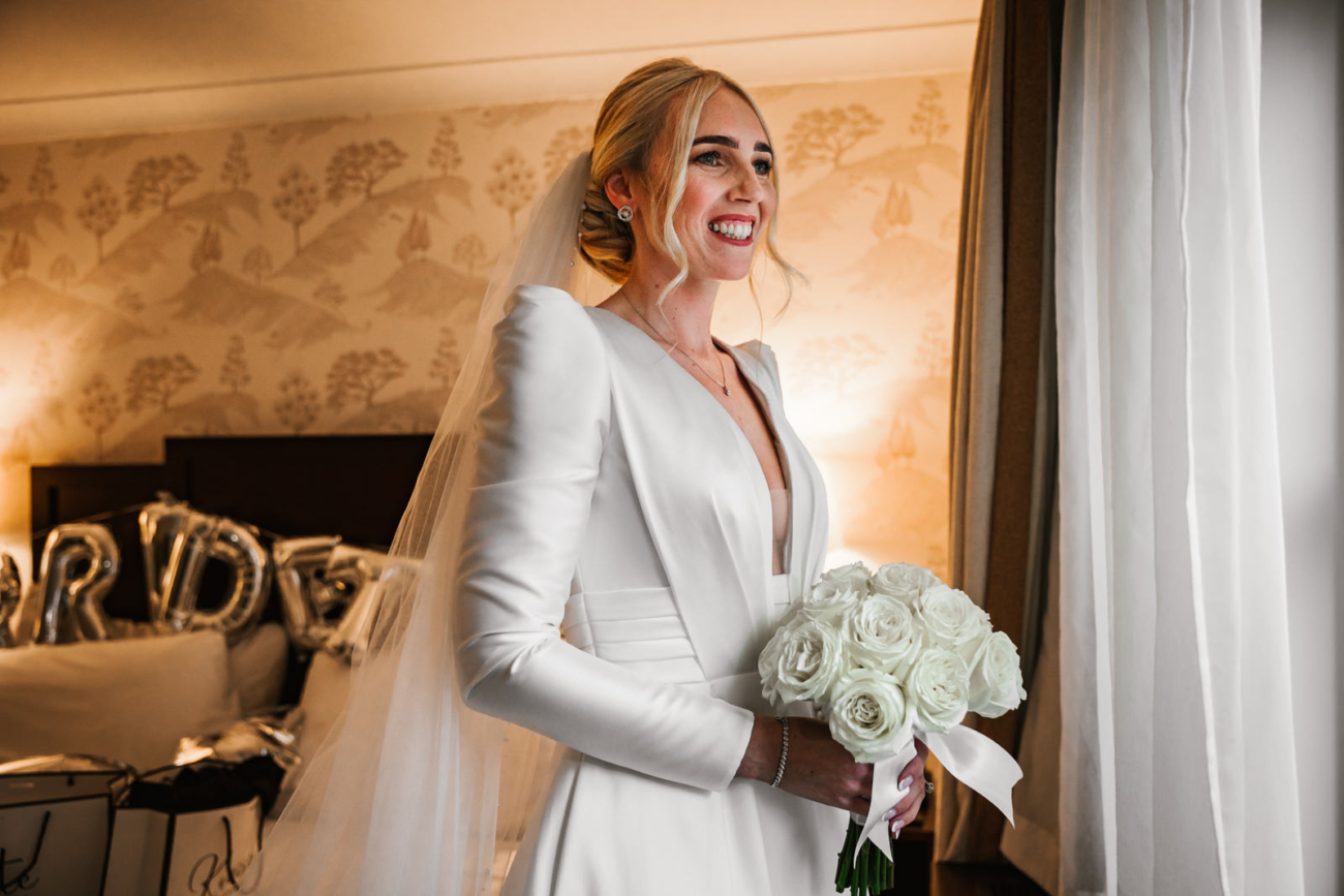 Bride in her dress looking through the window