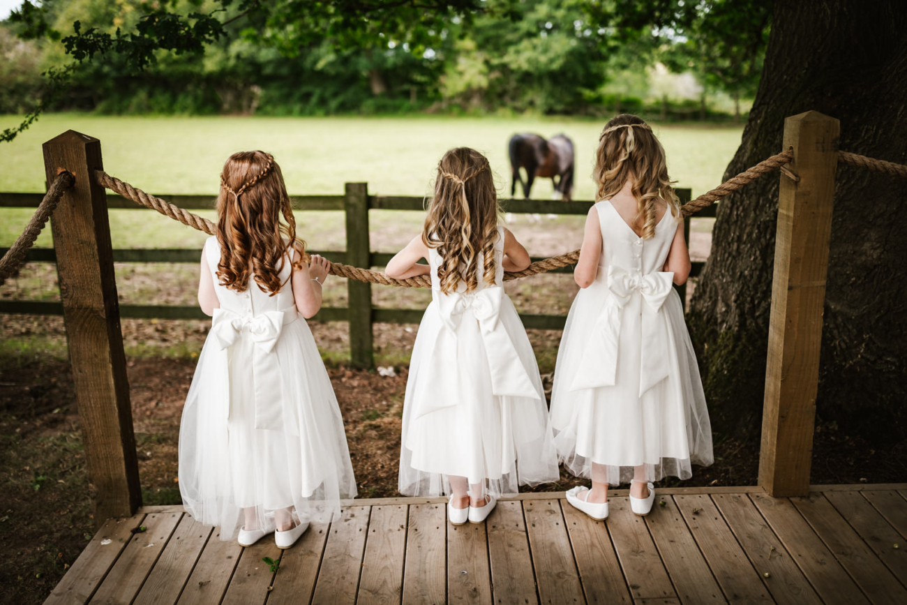 Rylands Farmhouse Wedding 7 Flower girls looking at a horse